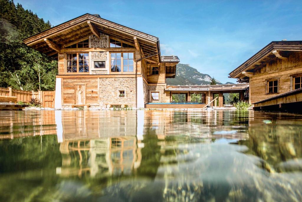 a house on top of a body of water at Verwöhnhotel Kristall in Pertisau