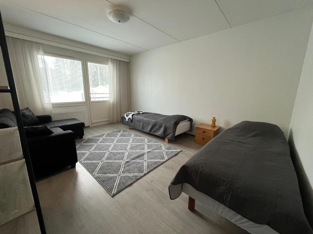 um quarto com 2 camas e um sofá em Tilava huoneisto em Lahti