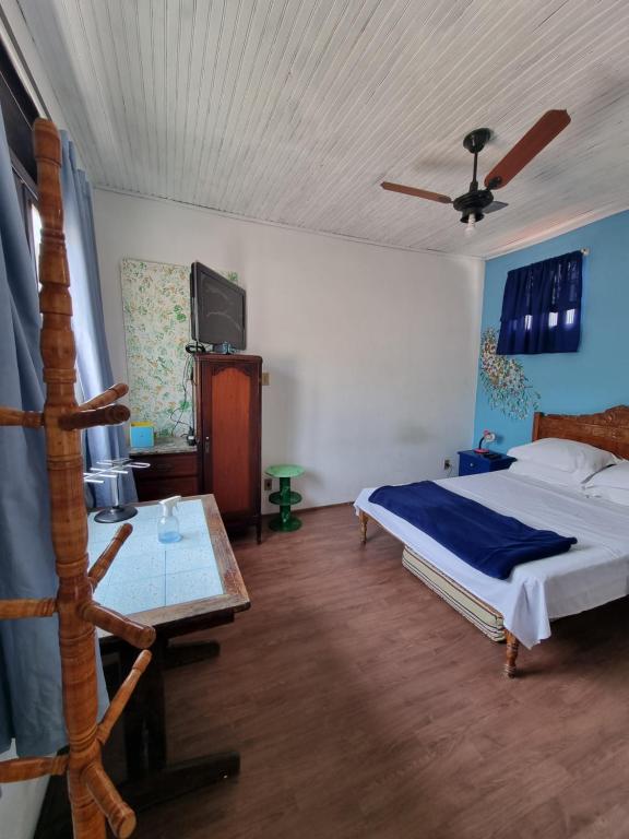 ein Schlafzimmer mit einem Bett und einem TV. in der Unterkunft No coração da Ilha in Rio de Janeiro