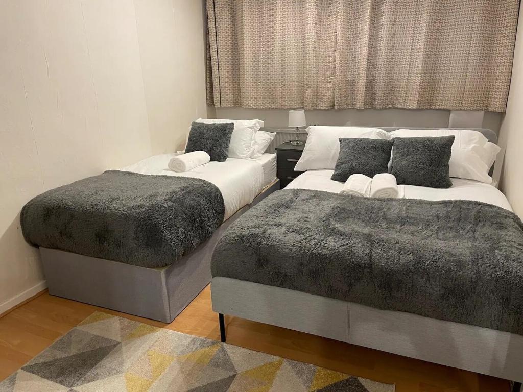 Duas camas sentadas uma ao lado da outra num quarto em Well-preserved cozy1BR flat in LCY with free parking em Londres