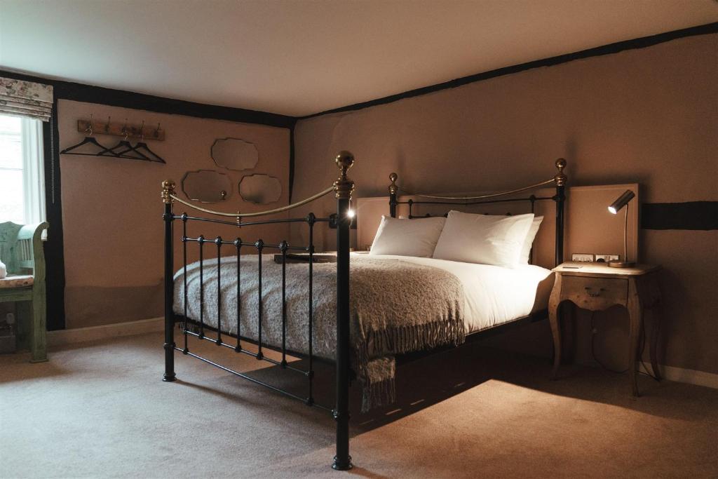 a bedroom with a bed with a black frame at The Woolpack Hotel in Tenterden