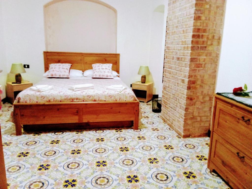 a bedroom with a bed and a tile floor at affittacamere prezioso in Gaeta