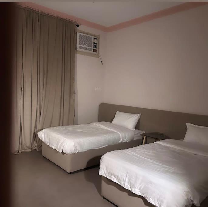 um quarto com duas camas e uma janela em شقة واسعه بتصميم حديث em Al Fayşalīyah