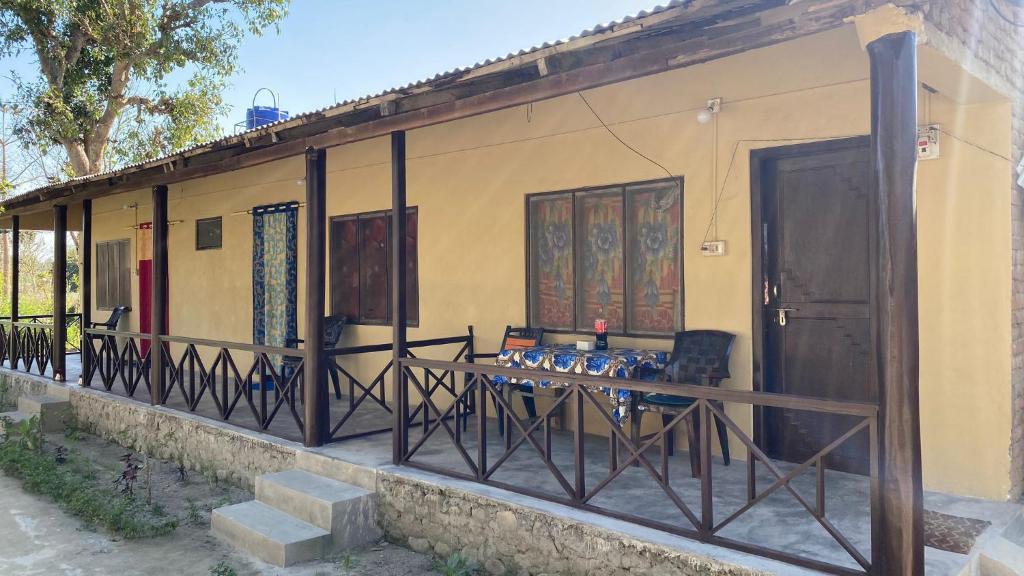 Nanu's Bardiya Homestay في Bhurkīā: منزل أمامه طاولة وكراسي