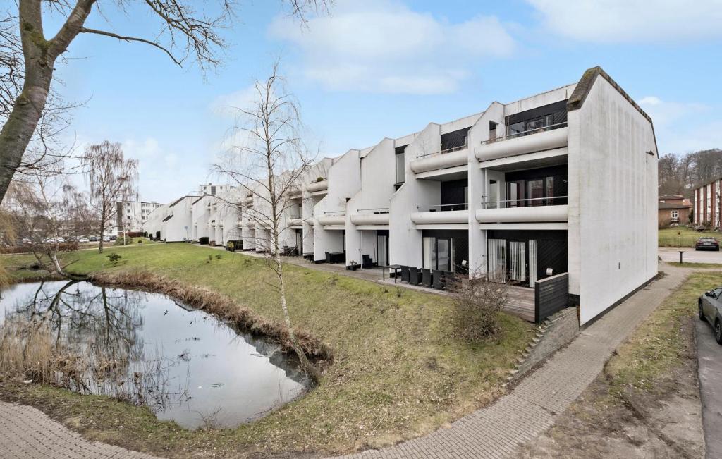 a building with a pond in front of it at 1 Bedroom Beautiful Home In Helsingr in Helsingør