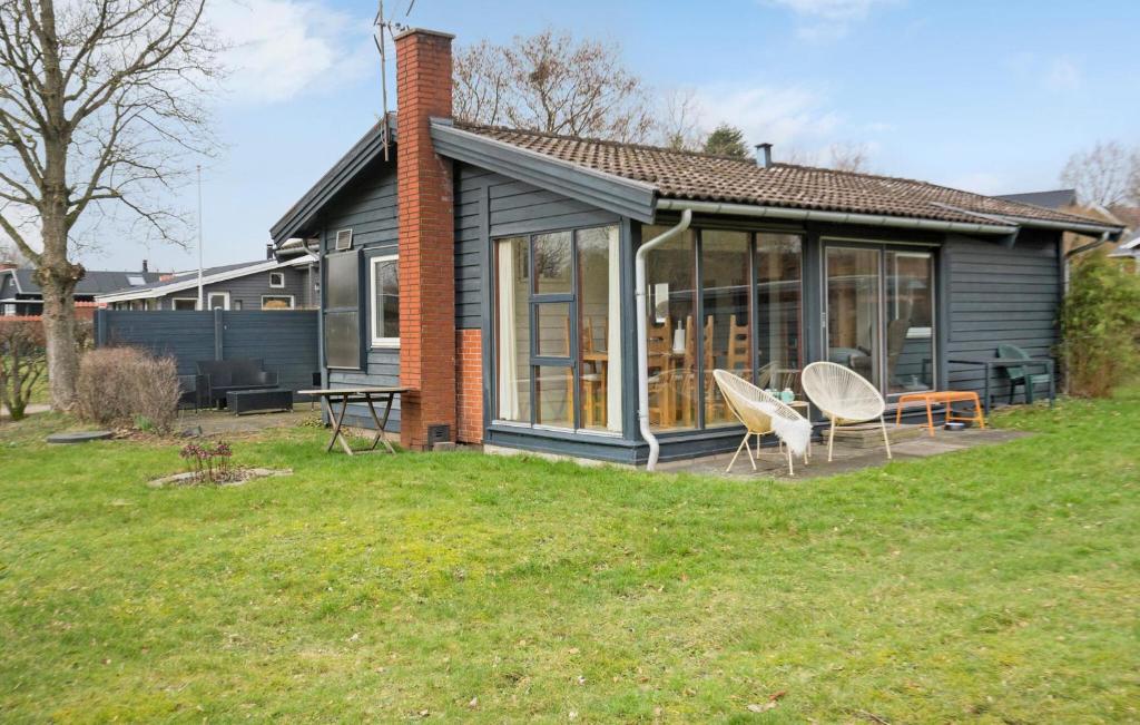 une maison avec deux chaises et une table dans une cour dans l'établissement Nice Home In Brkop With Wi-fi, à Børkop