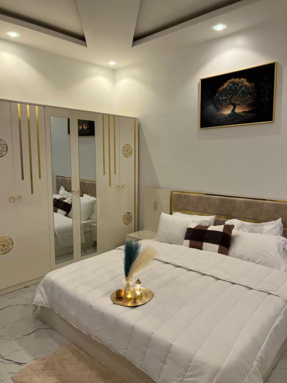 um quarto com uma grande cama branca e um espelho em Résidence Mounir em Thiès