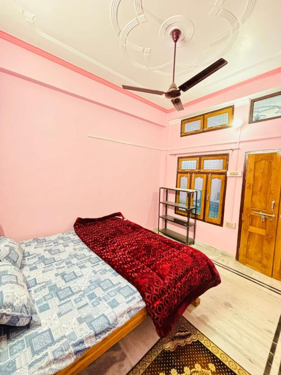 1 dormitorio con 1 cama y ventilador de techo en Sardar Patel Homestay, en Ayodhya