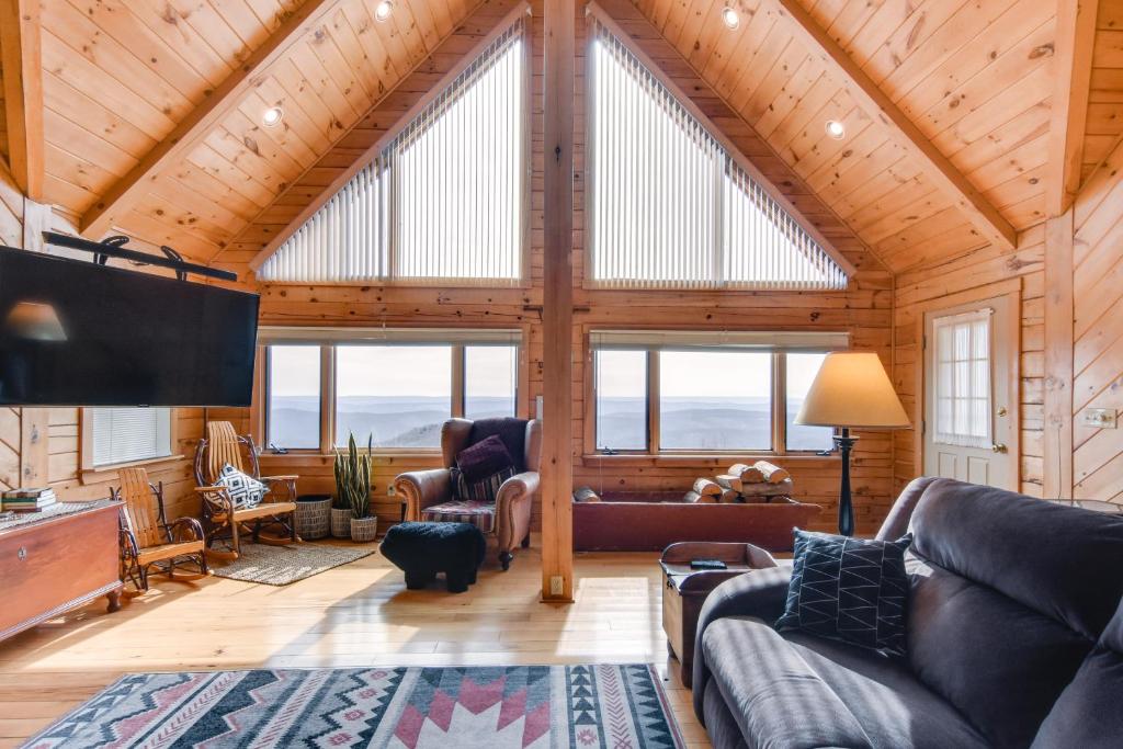 een woonkamer met een groot gewelfd plafond bij Spacious Howard Cabin with Wraparound Deck and Views! 