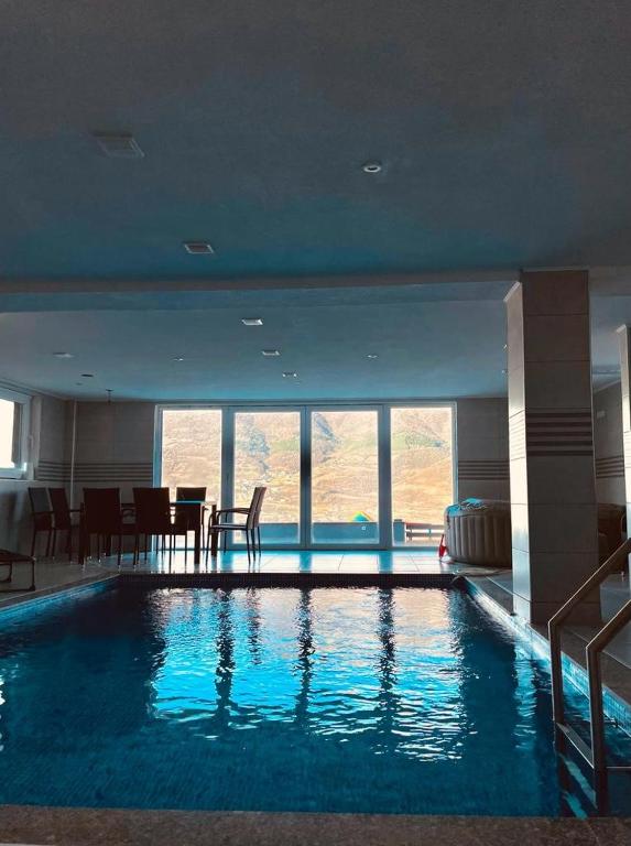a large swimming pool in a building with a table and chairs at Villa SHAMS in Travnik
