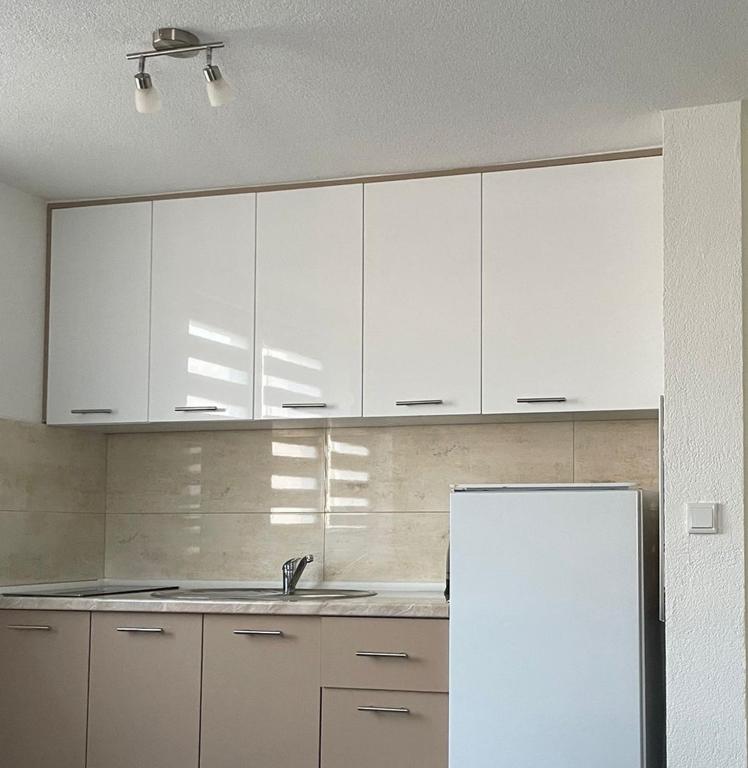a kitchen with white cabinets and a sink and a refrigerator at Villa SHAMS in Travnik