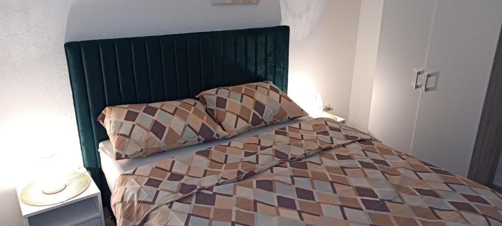 a bed with a green headboard in a bedroom at Villa SHAMS in Travnik