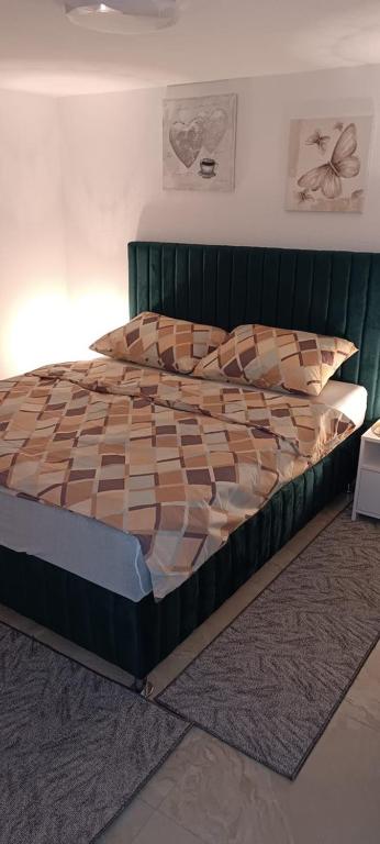 a bed in a bedroom with a green headboard at Villa SHAMS in Travnik