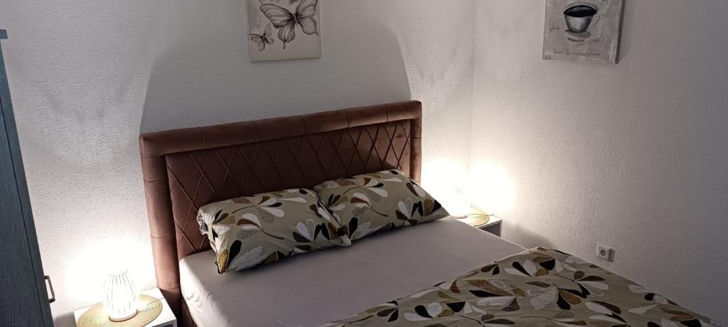 ein Bett in einem Schlafzimmer mit zwei eingeschalteten Lampen in der Unterkunft Villa SHAMS in Travnik
