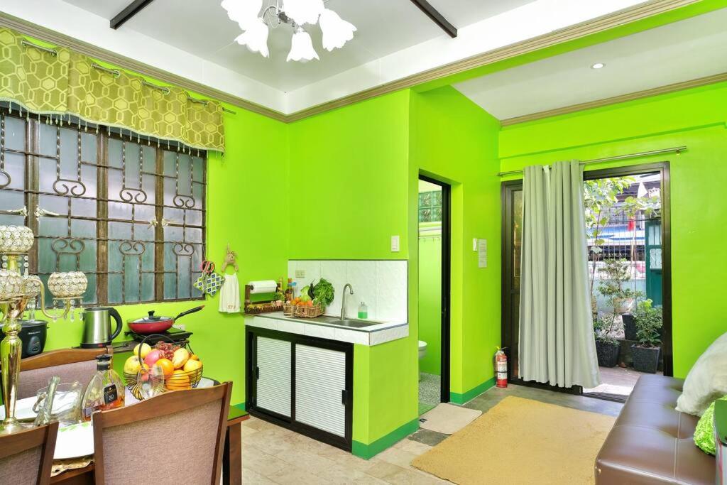 eine Küche mit hellgrünen Wänden und einem Tisch in der Unterkunft Golden V Executive Homes Unit I in Malolos