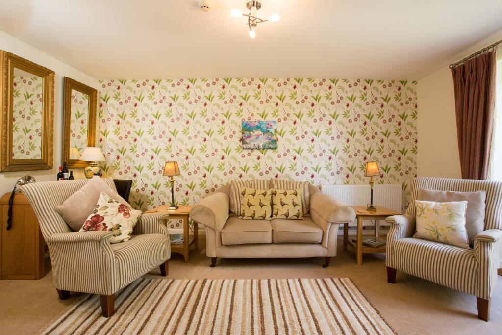 a living room with two chairs and a couch at Penbontbren Luxury Bed and Breakfast in Aberporth