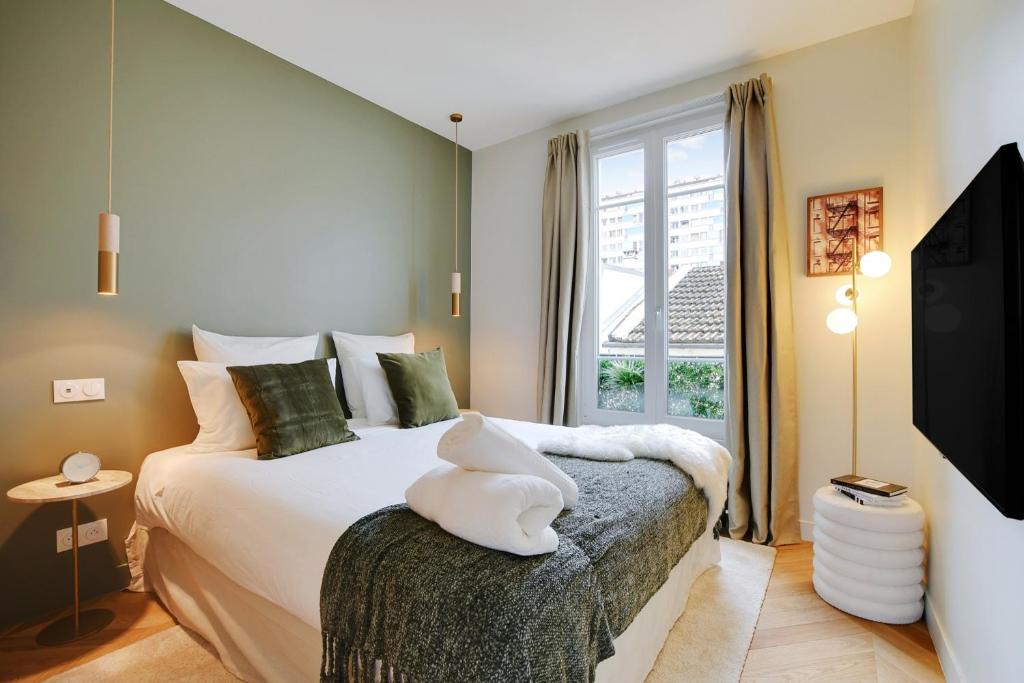 a bedroom with a large bed and a window at Suite Deluxe 2 by Les Maisons de Charloc Homes in Boulogne-Billancourt