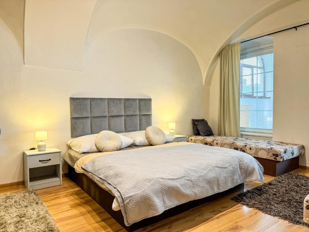 1 dormitorio con cama grande y ventana grande en Old Town apt. A/C and parking, en Banská Bystrica