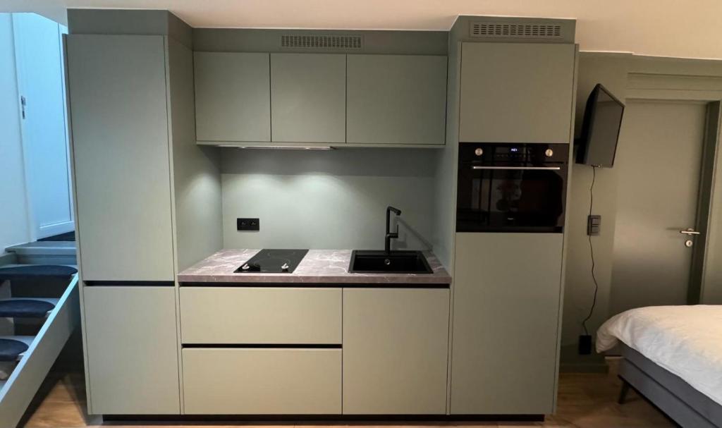 een kleine keuken met witte kasten en een fornuis bij J1 - Urban studio in Antwerp in Antwerpen