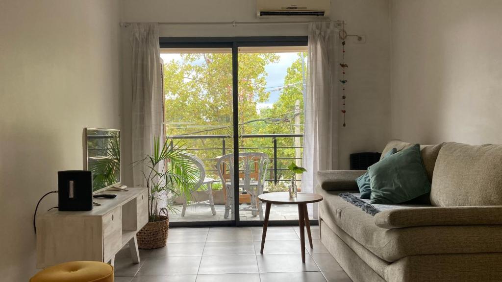 ein Wohnzimmer mit einem Sofa und einem großen Fenster in der Unterkunft Tigre Apartment in Tigre