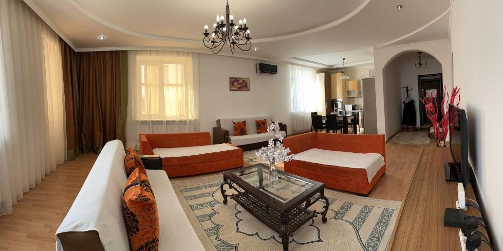 a living room with a couch and a table at Уютная и просторная 3х комнатная в ЦЕНТРЕ in Uralsk