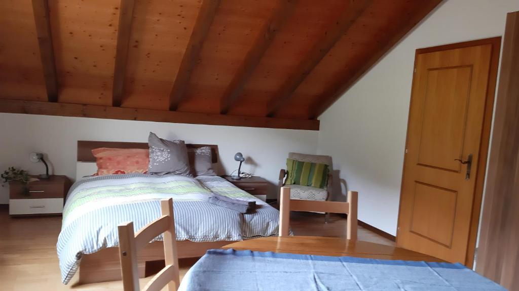 una camera con letto e soffitto in legno di La capucine a Sonvilier