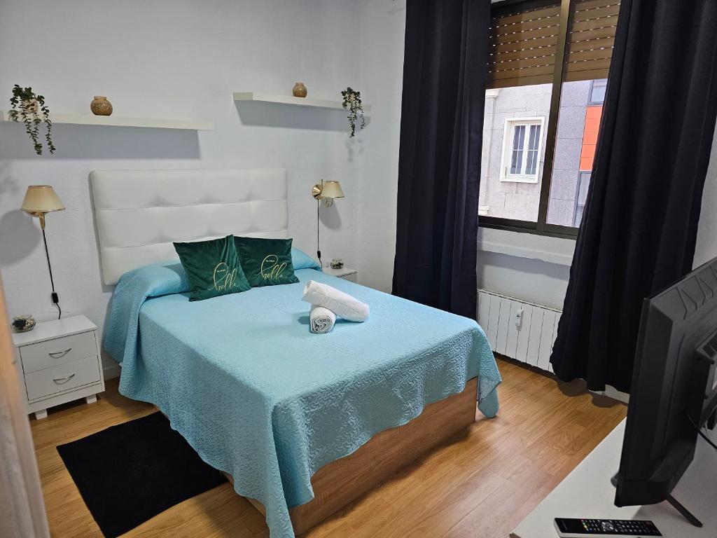 - une chambre avec un lit doté d'une couverture bleue et d'une fenêtre dans l'établissement Apartamento Gran Via Madrid W8.1, à Madrid