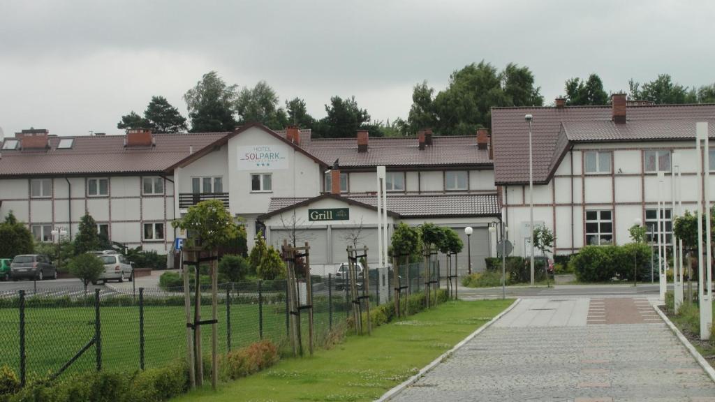 a building with a fence in front of it at Hotel Solpark in Kleszczów