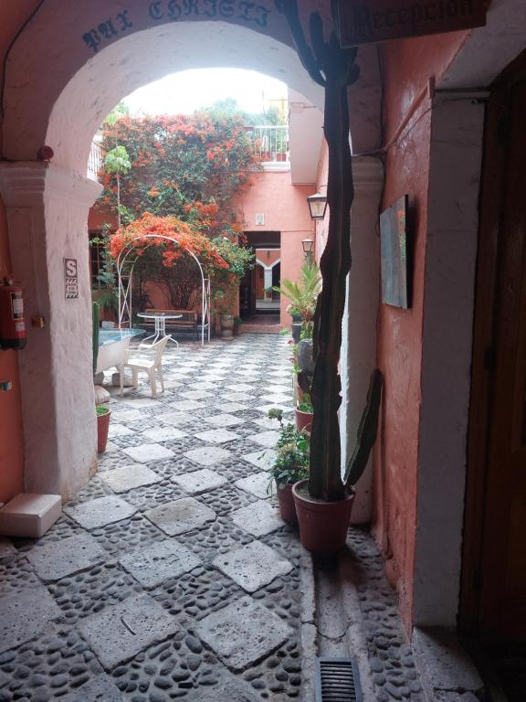 un callejón con un arco con macetas. en Posada Nueva España, en Arequipa