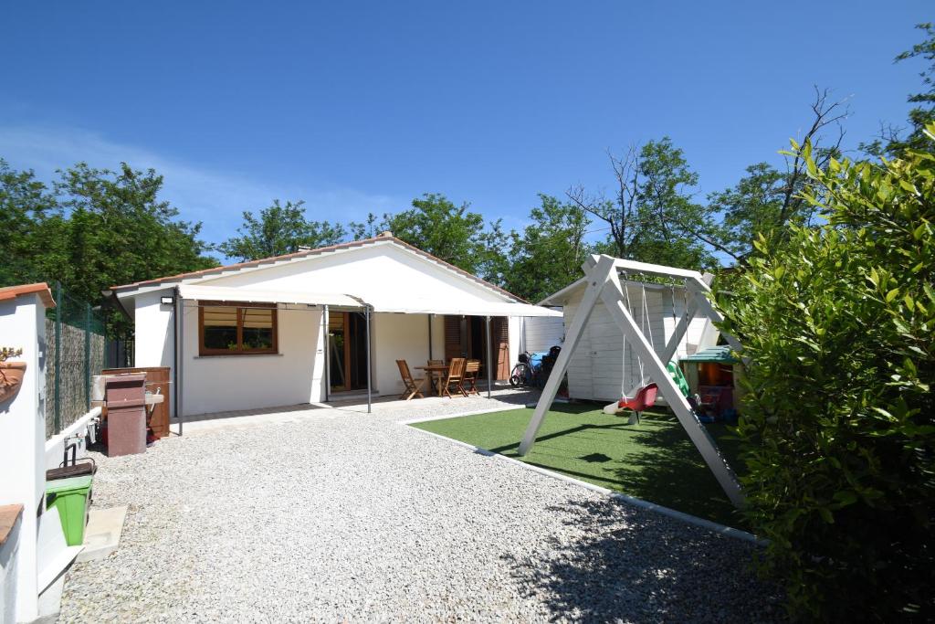 a backyard with a white tent and a playground at Villetta Orchidea - Indipendente con giardino privato in Marina di Campo