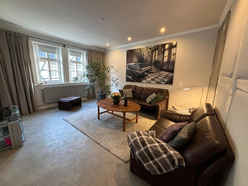 - un salon avec un canapé en cuir et une table dans l'établissement Ambiente am Breiten Tor Apartment 1, à Goslar