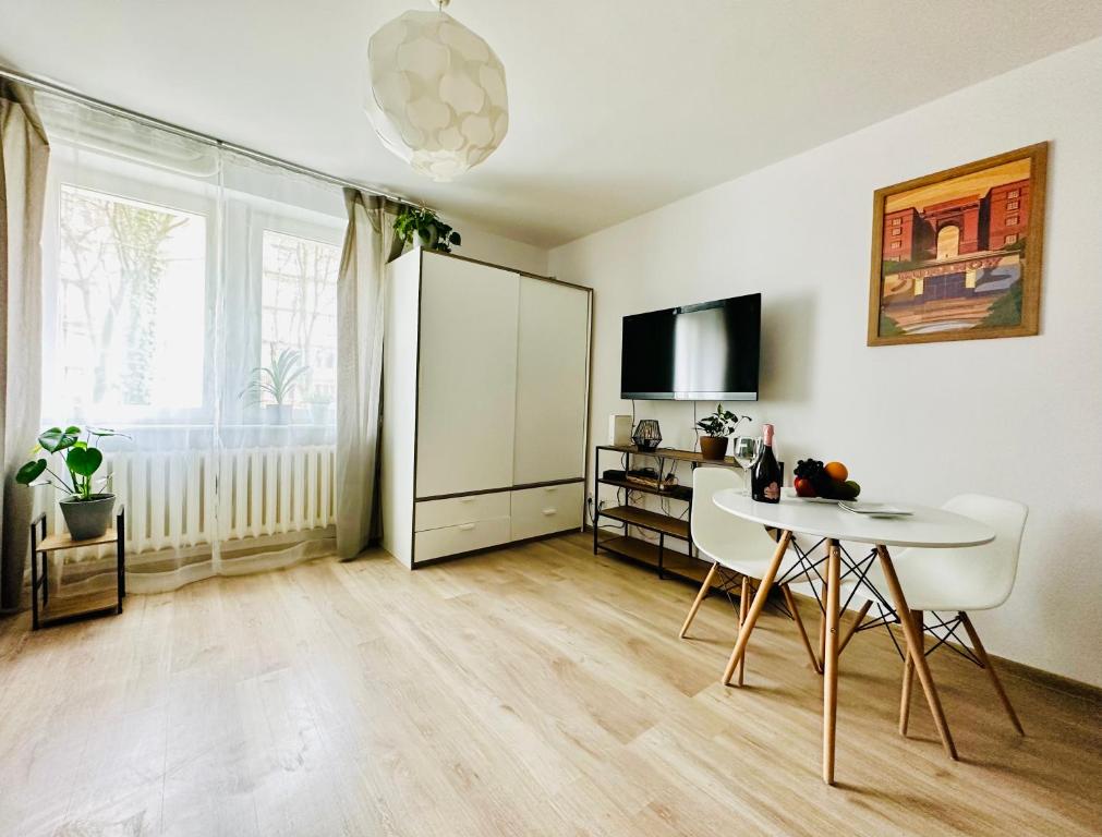 a living room with a table and a white refrigerator at Cosy Stay Muranów in Warsaw