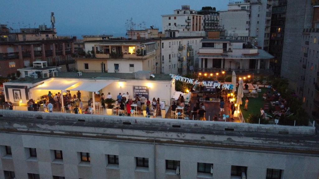 Un groupe de personnes debout au sommet d'un bâtiment dans l'établissement Ostello Bello Napoli, à Naples