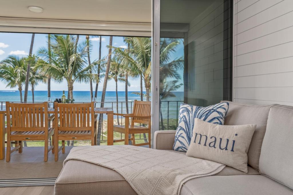 Una sala de estar con un sofá y vista al mar. en Fully Remodeled Ocean Front Comfort HKOK316, en Kihei