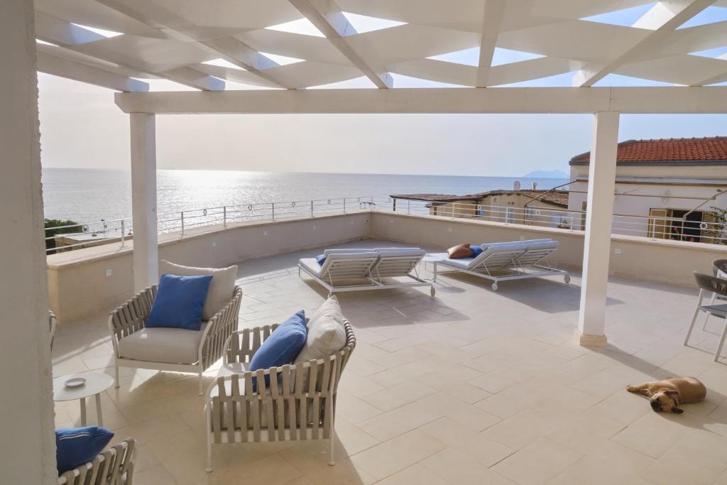 a patio with chairs and tables and the ocean at PALAZZO SAN ROCCO in Sperlonga