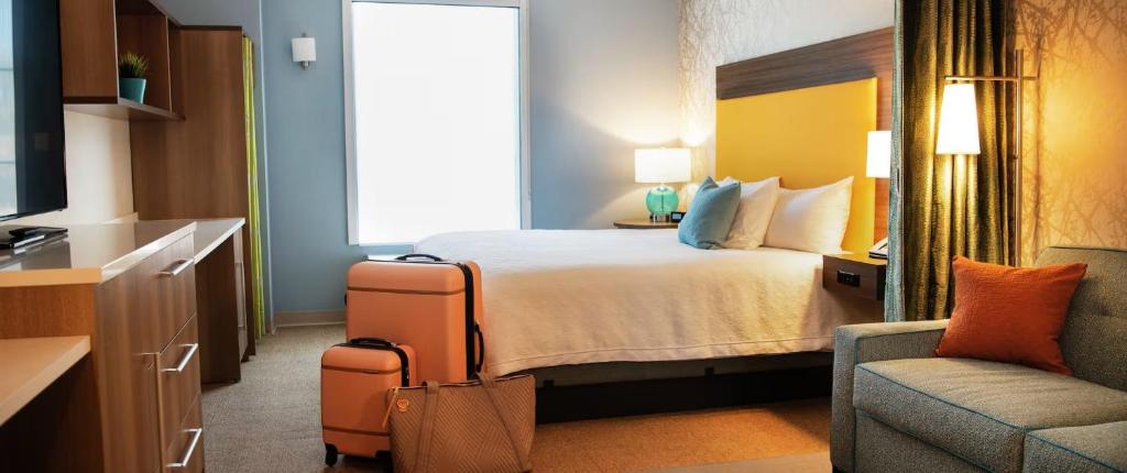 a hotel room with a bed and a chair at Home2 Suites By Hilton Falls Church in Falls Church