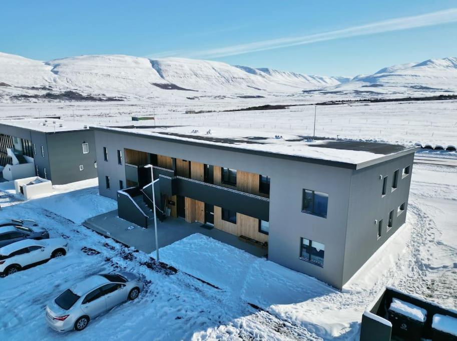 a building with a car parked in the snow at Beautiful apartment in Akureyri in Akureyri