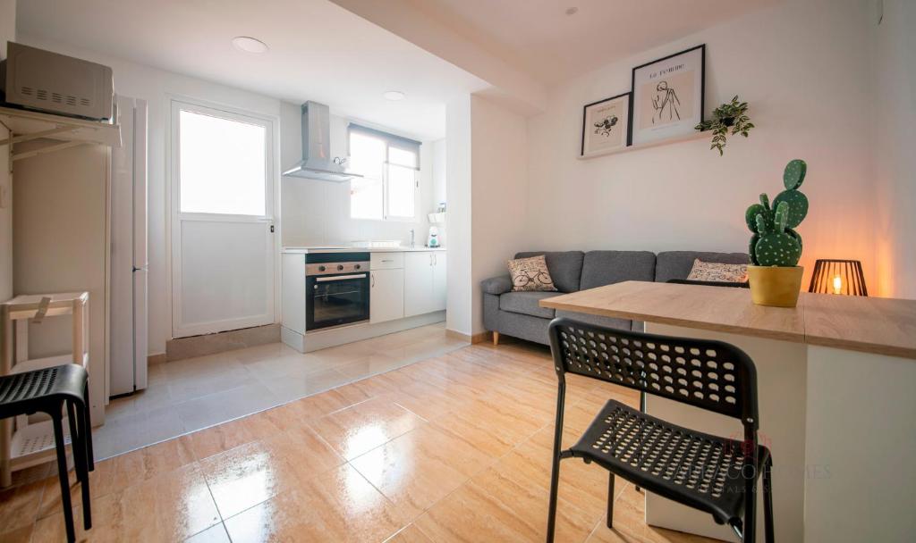eine Küche und ein Wohnzimmer mit einem Tisch und einem Sofa in der Unterkunft TarracoHomes-TH08 Apartamento con patio privado en el centro de Tarragona in Tarragona