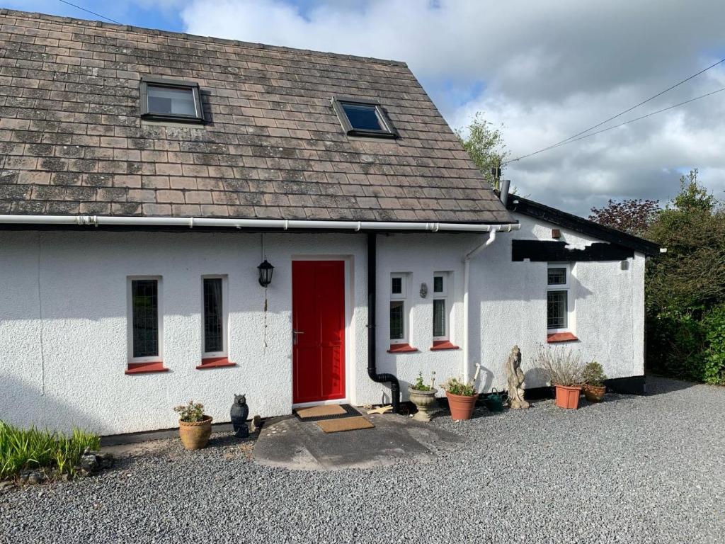 a white house with a red door at Barn Owl Cottage, The Welsh Reindeer Retreat, Ystradfach Farm , Llandyfaelog, Carmarthen , SA17 5NY in Carmarthen