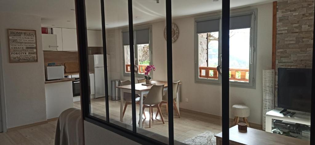 eine Küche und ein Esszimmer mit einem Tisch und einer Küche in der Unterkunft Appartement cosy au coeur du Mercantour in Valdeblore