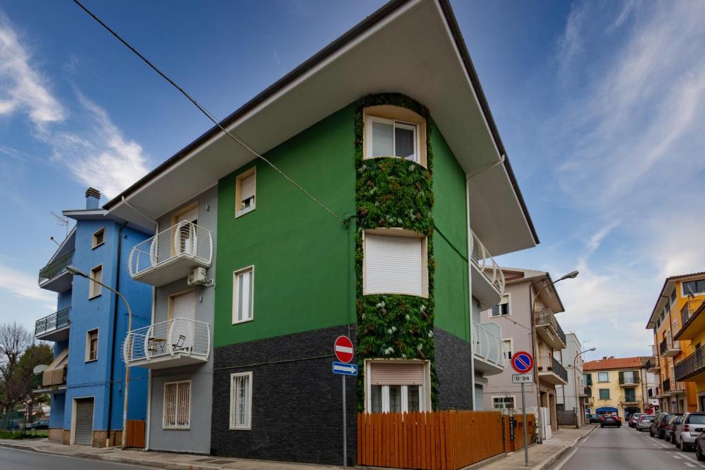 un bâtiment vert avec des plantes sur son côté dans l'établissement Appartamento Stella Marina 3 - MyHo Casa, à San Benedetto del Tronto