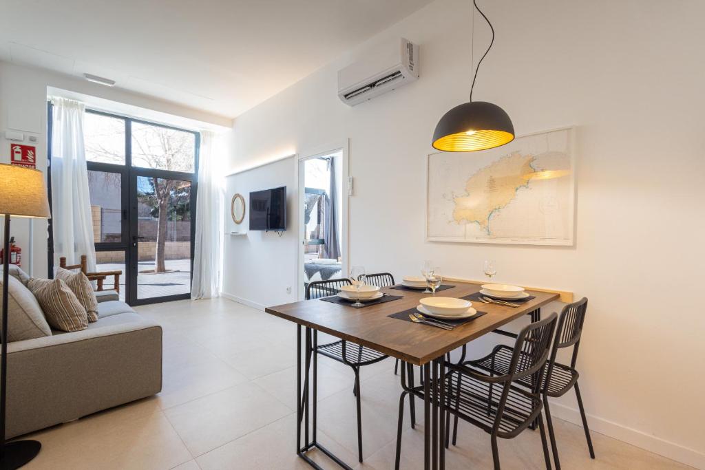 a dining room and living room with a table and chairs at FLORIT FLATS - The Pitiusas Rooms in Valencia