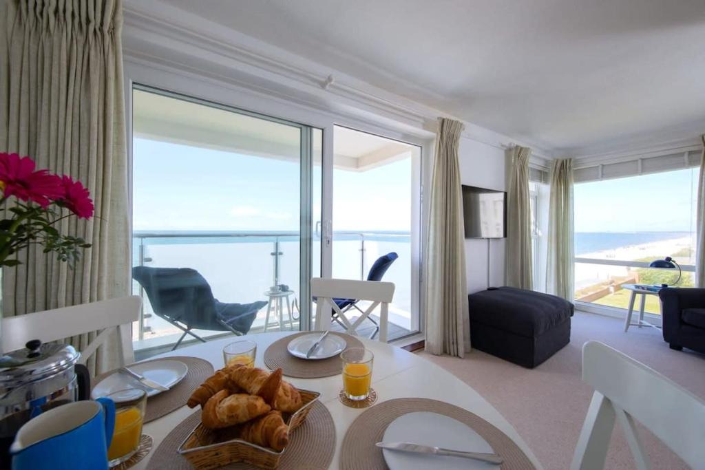 a living room with a table with a plate of food at High-End Beachfront Getaway Sea View King Bed in East Wittering