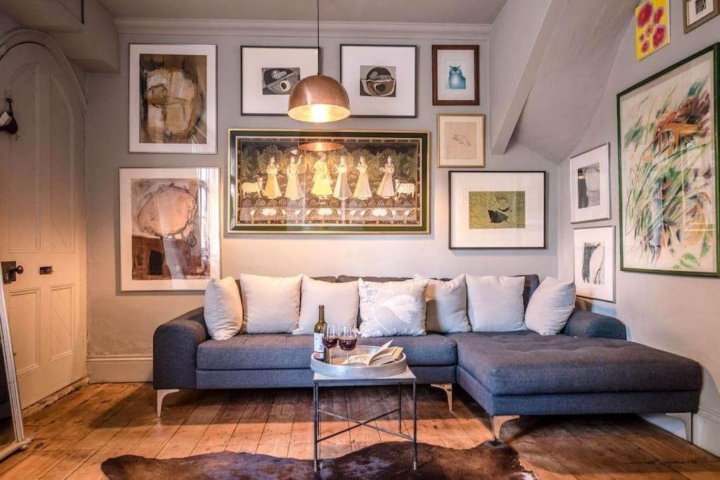 a living room with a blue couch and pictures on the wall at Dove Point, Orford in Woodbridge