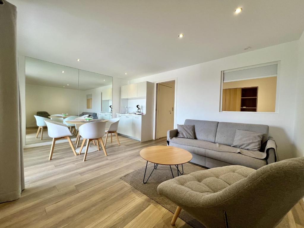 a living room with a couch and a table at Beau 2 pièces proche mer - piscine et clim in Vallauris