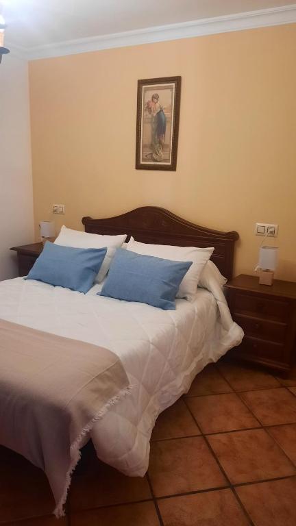 a bedroom with a large bed with blue pillows at La sierra in Algar