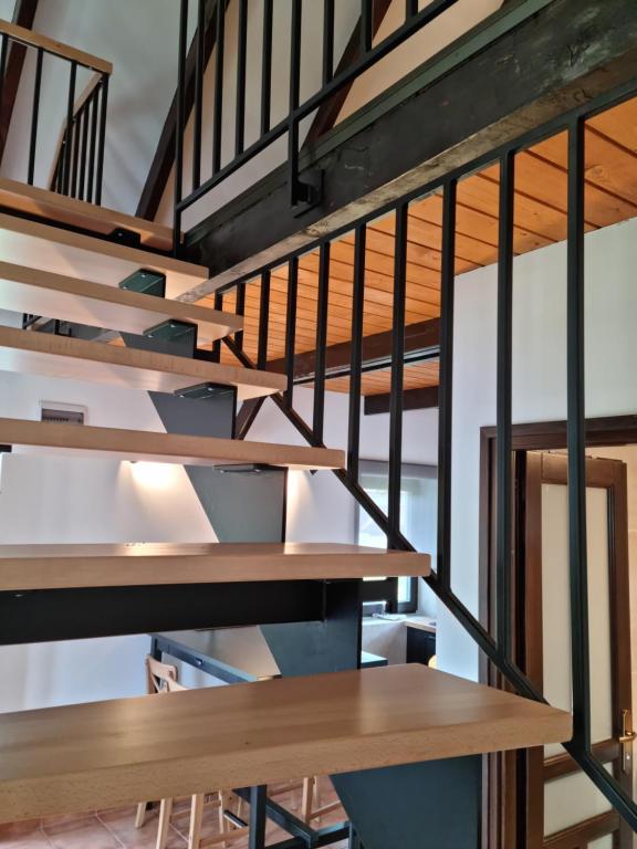 eine Treppe in einem Loft mit Holz- und Metallgeländer in der Unterkunft Cooles Lofthouse mit Pool in Kiskunmajsa