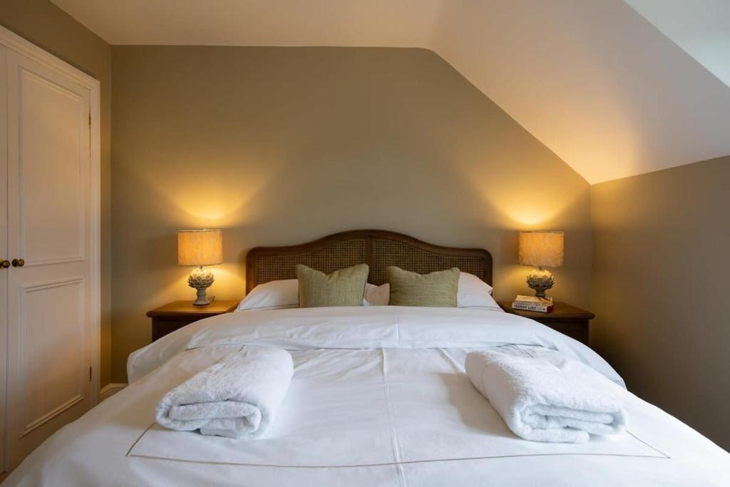a bedroom with two white towels on a bed at Cosy Cottage in Beautiful South Downs Walk 2 Pub in Chichester