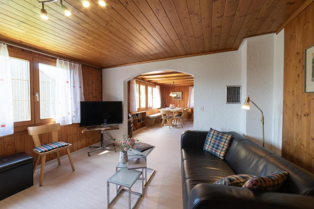 uma sala de estar com um sofá de couro e uma televisão em Central em Wildhaus