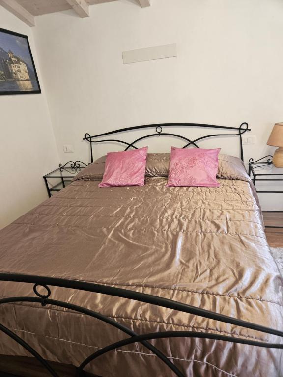 un letto con due cuscini rosa sopra di Casa Mary a Camaiore